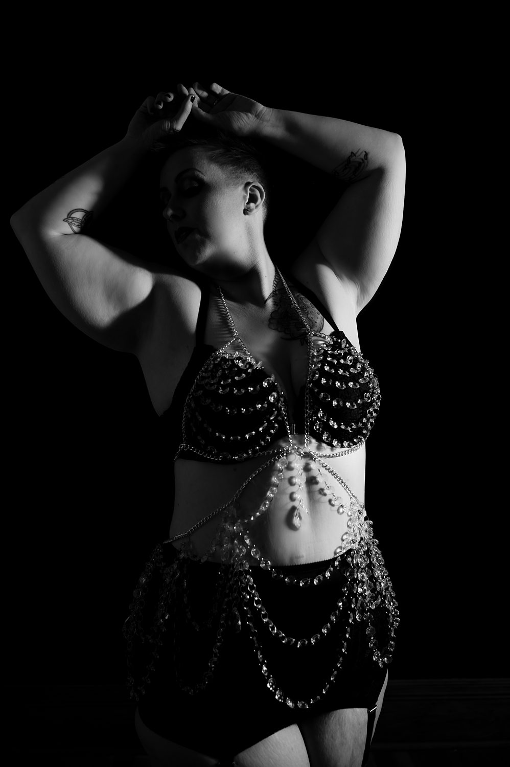 Fine art boudoir photo of woman standing tall wearing luxe body jewelry.