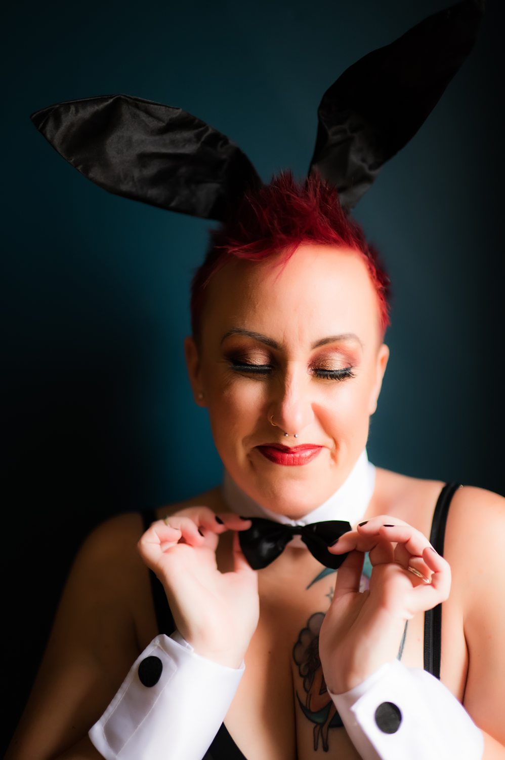 Portrait of woman smirking wearing sexy playboy bunny boudoir outfit.