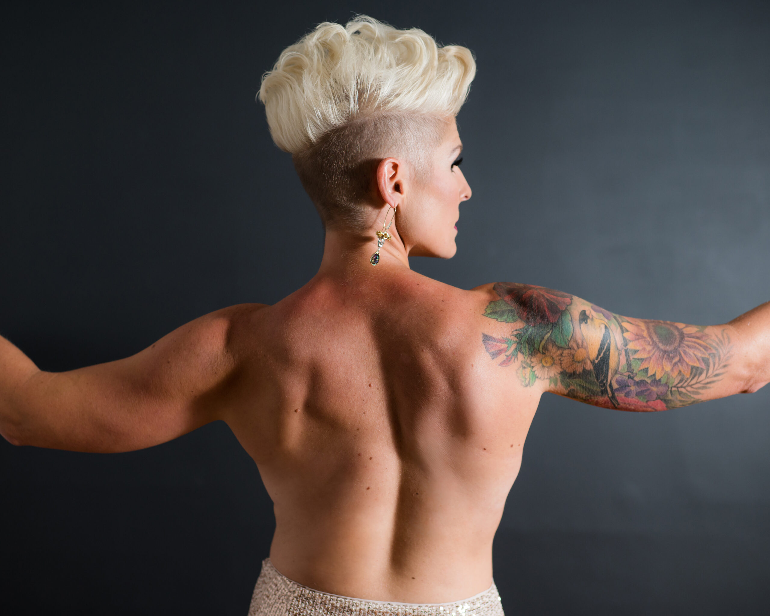 A woman with a unique hairstyle posing backwards for her boudoir shoot