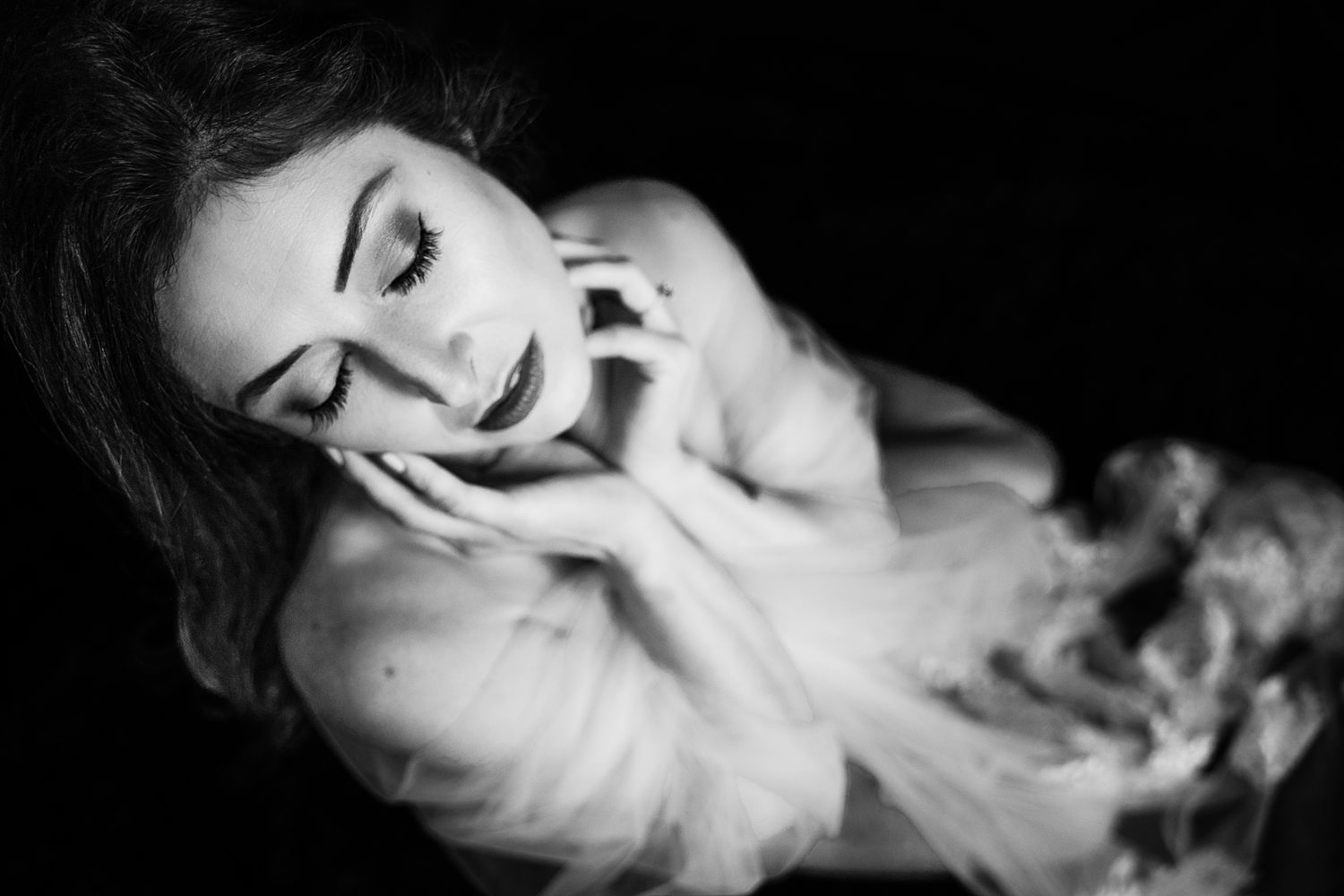 Black-and-white editorial boudoir photo of woman wearing wedding veil.