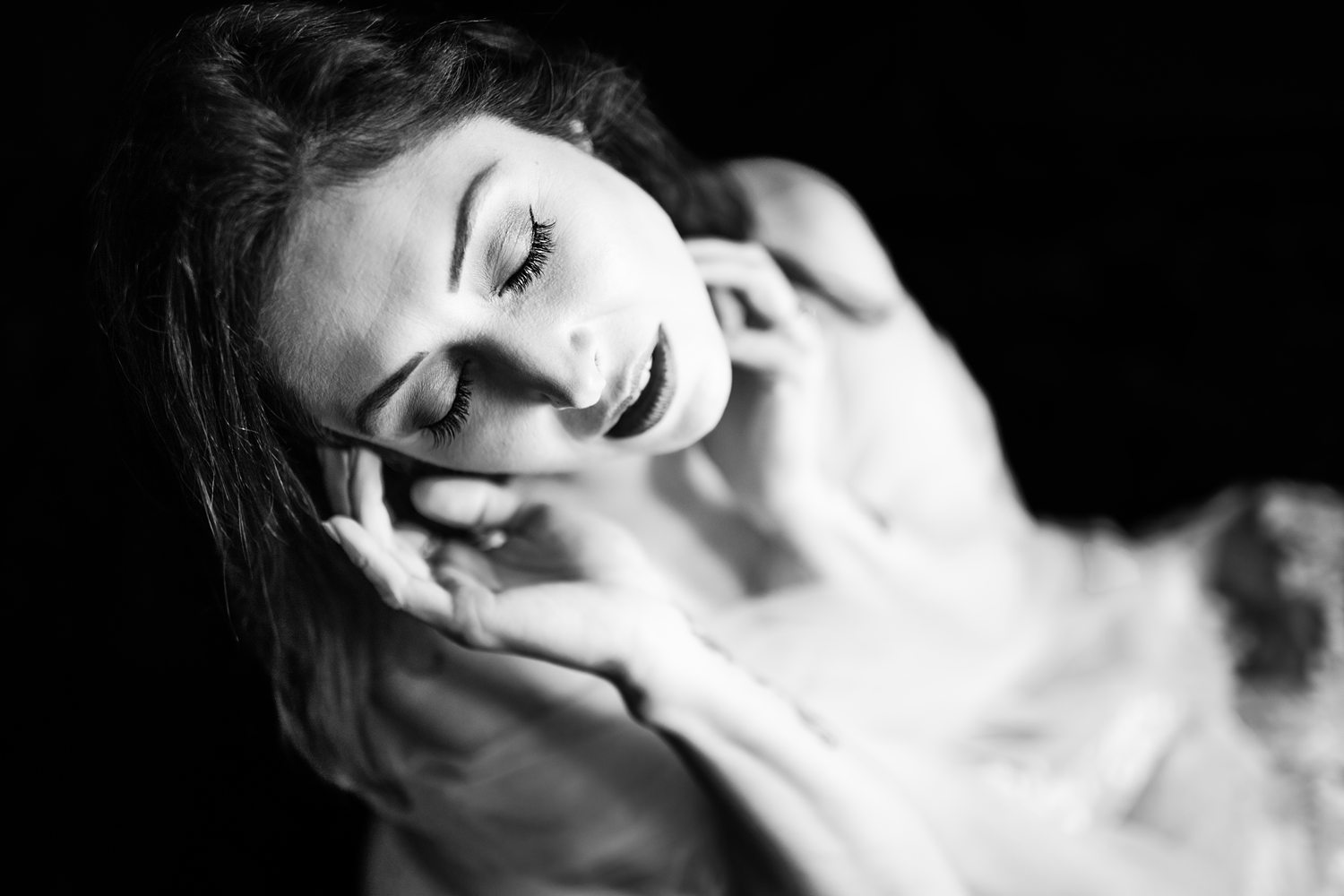 Boudoir portrait of woman gently resting her hands on her face during confidence building boudoir session with Betsy McCue Pictures.