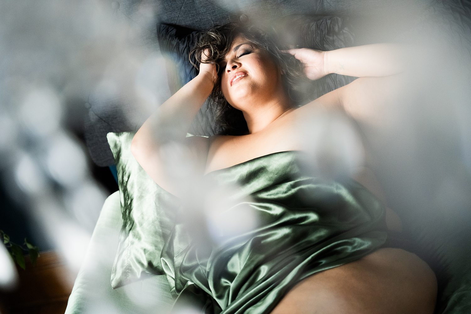 Sensual boudoir photo of woman in-the-sheets during empowering boudoir session with Betsy McCue Pictures.