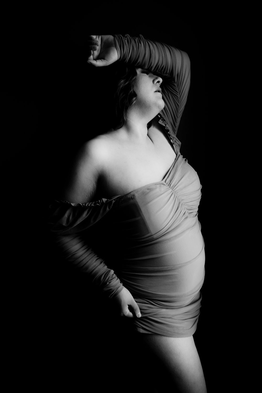 Woman in her 30s wearing an off the shoulder dress during mid-Michigan boudoir session.