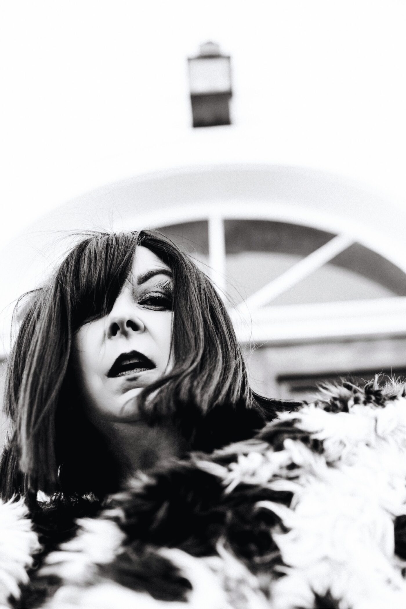 Betsy McCue Gibson, award-winning international intimate boudoir editorial photographer in Kalamazoo Michigan, photographed in black-and-white wearing fur coat.