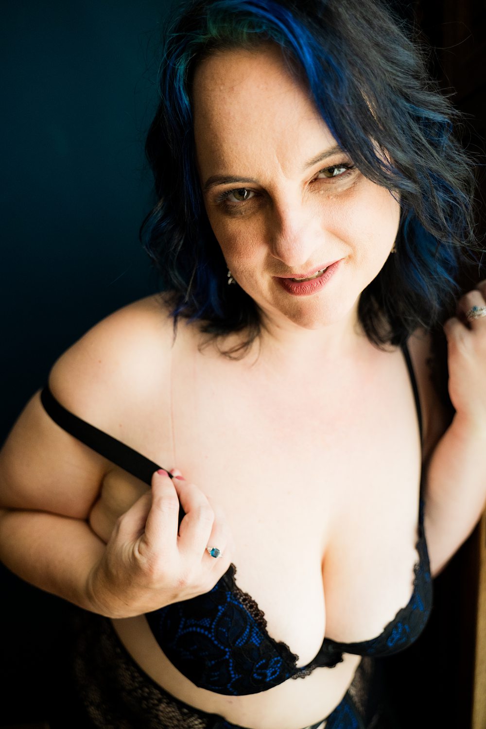 Boudoir photo of woman in black and blue lace bra