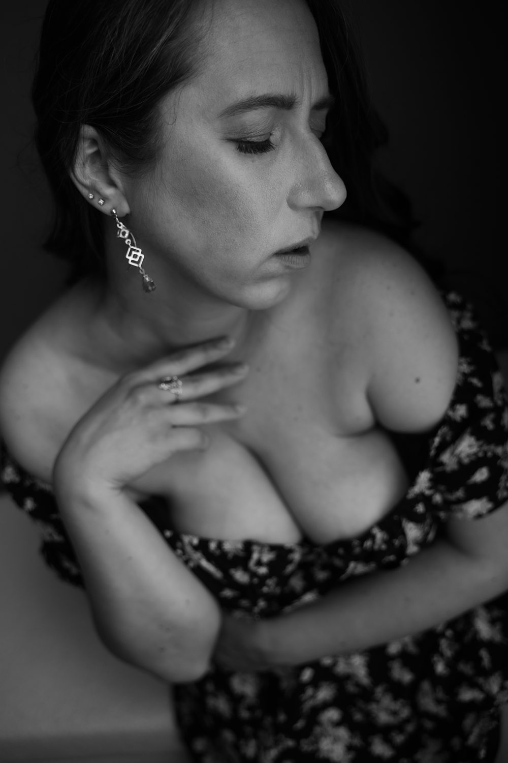 Emotive black-and-white photo of a woman gently touching her hand to her neck.