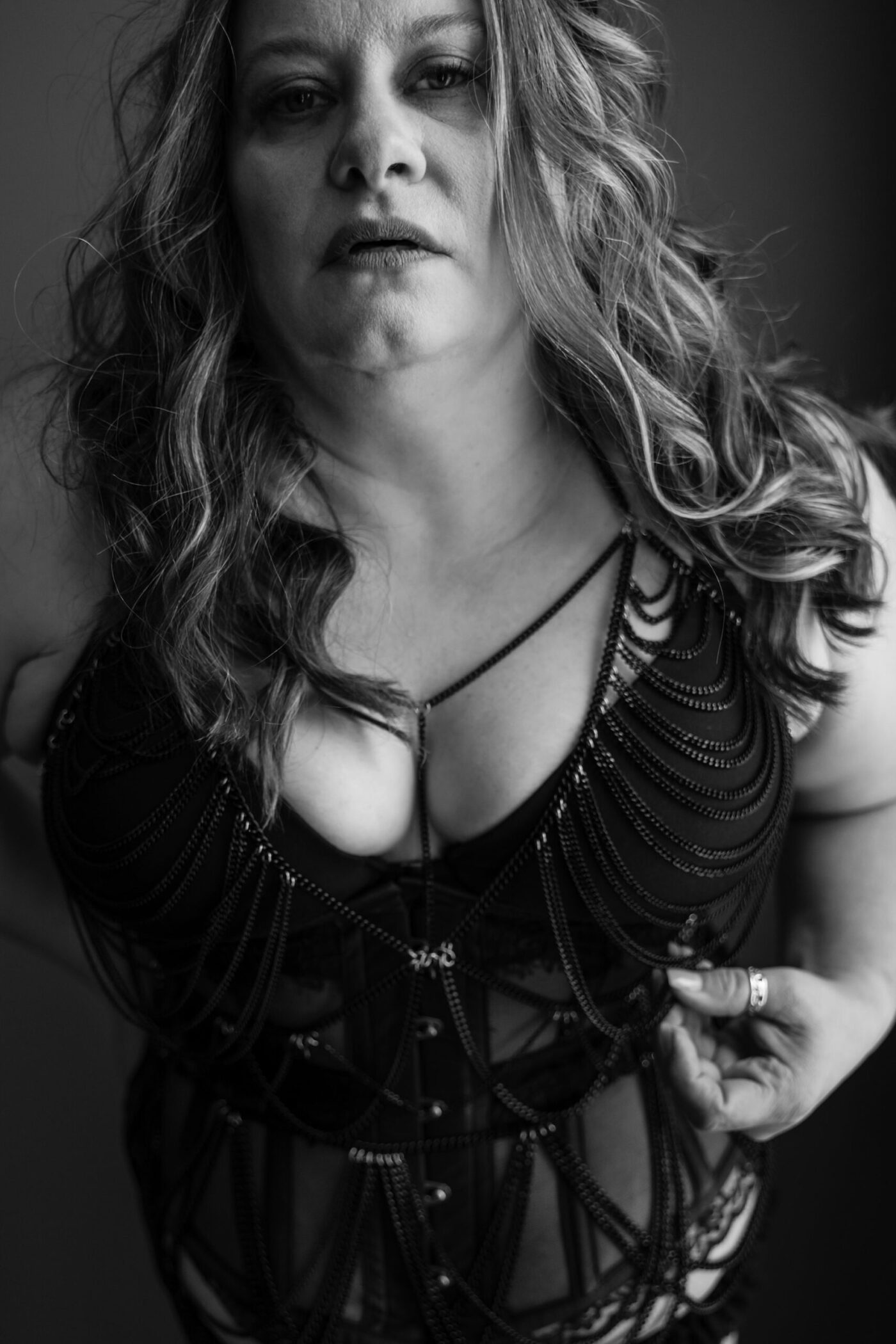Radiant 40-something woman during empowering fine art boudoir session in West Michigan, celebrating her confident transformation
