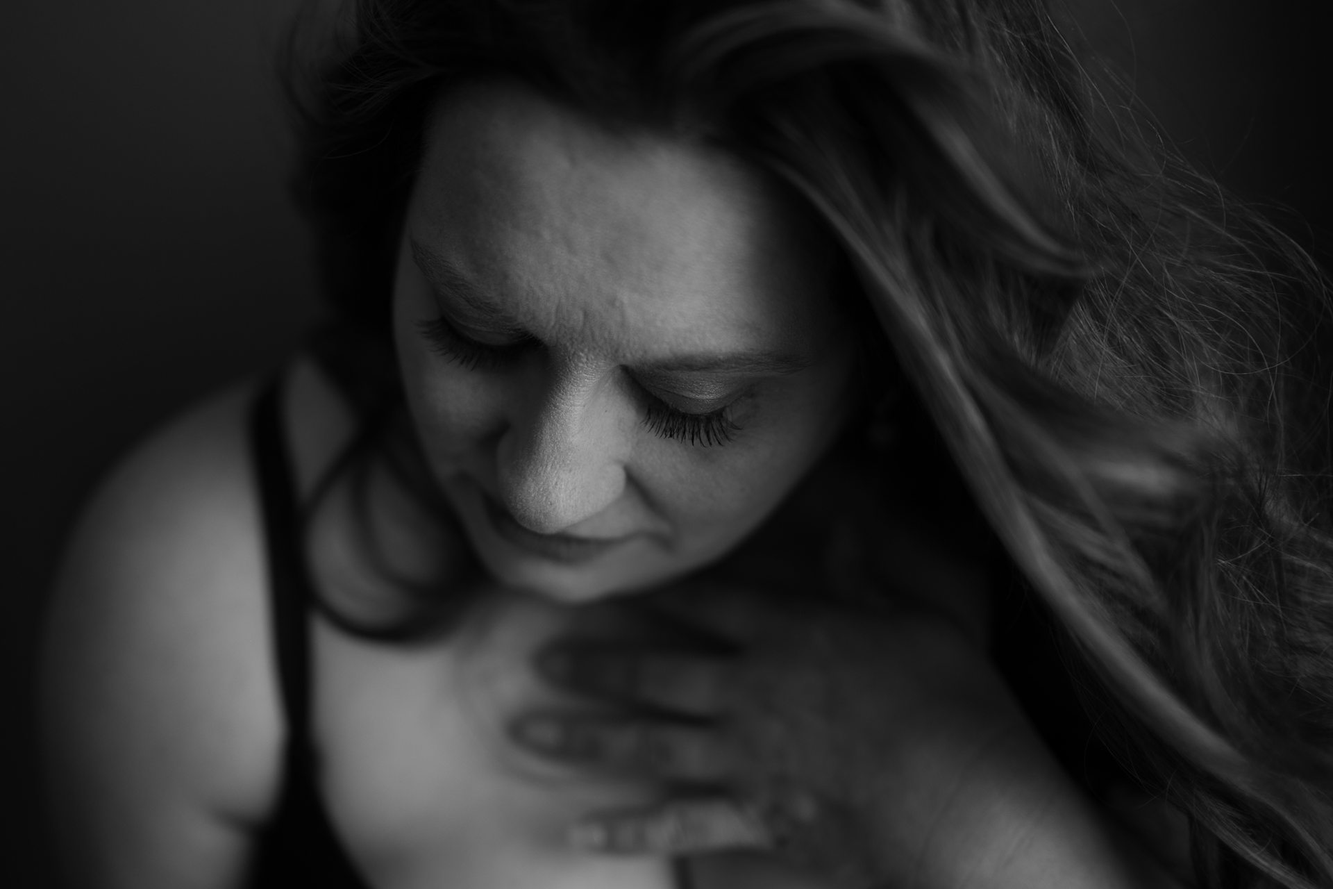 Confident mature woman posing gracefully during fine art boudoir session in Kalamazoo, embracing empowerment and self-love
